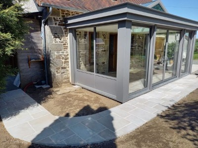 Réalisation d'une maçonnerie de véranda avec une grande ouverture entre les deux pièces de 4 mètres de long une terrasse sur plot